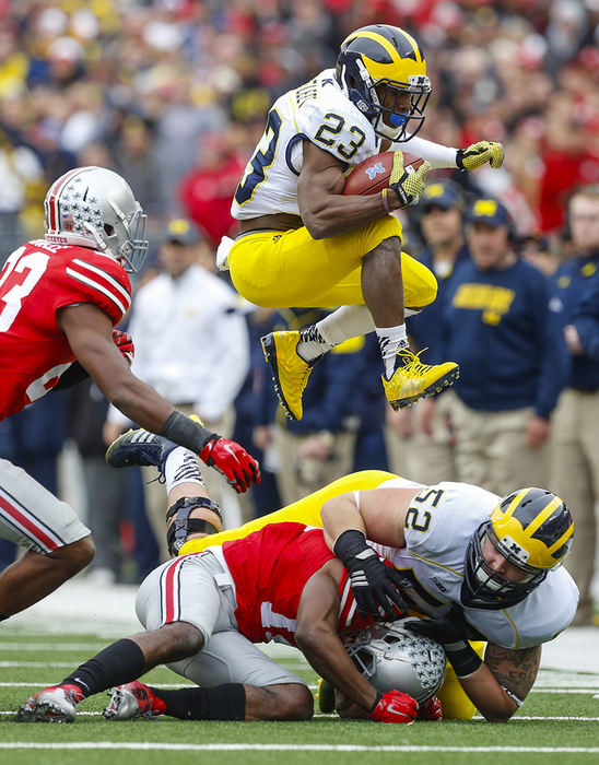 Sports - 2nd place - University of Michigan football player Dennis Norfleet leaps over teammate Mason Cole (52) for a first down against Ohio State University during the second quarter at Ohio Stadium. The Buckeyes won the battle 42-28. (Andy Morrison / The (Toledo) Blade)