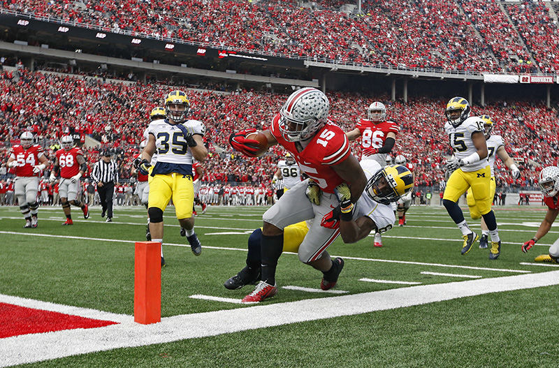 Story - 2nd place - Ohio State running back Ezekiel Elliott (15) gets pulled down my Michigan defensive back Raymon Taylor (6) at the 2 yard line in the 1st quarter of their game against Michigan at Ohio Stadium in Columbus. (Kyle Robertson / The Columbus Dispatch)