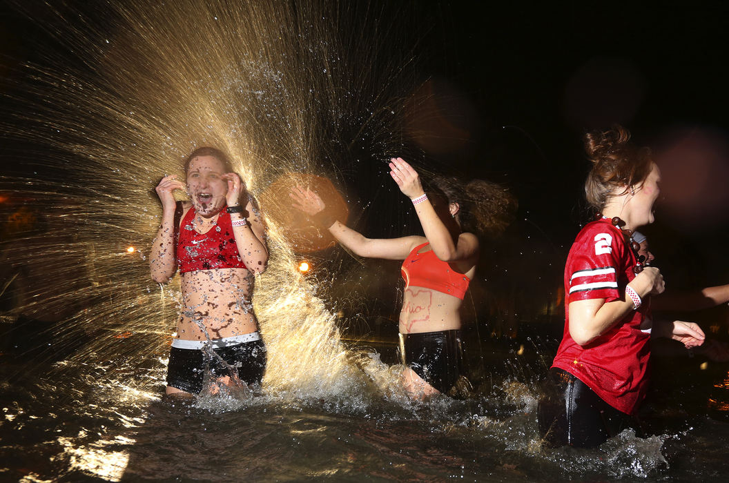 Feature - HM - OSU students Sarah Laborie (left) gets splashed by friend Miranda Wagner at Mirror Lake in the annual pre Michigan jump. (Eric Albrecht / The Columbus Dispatch)