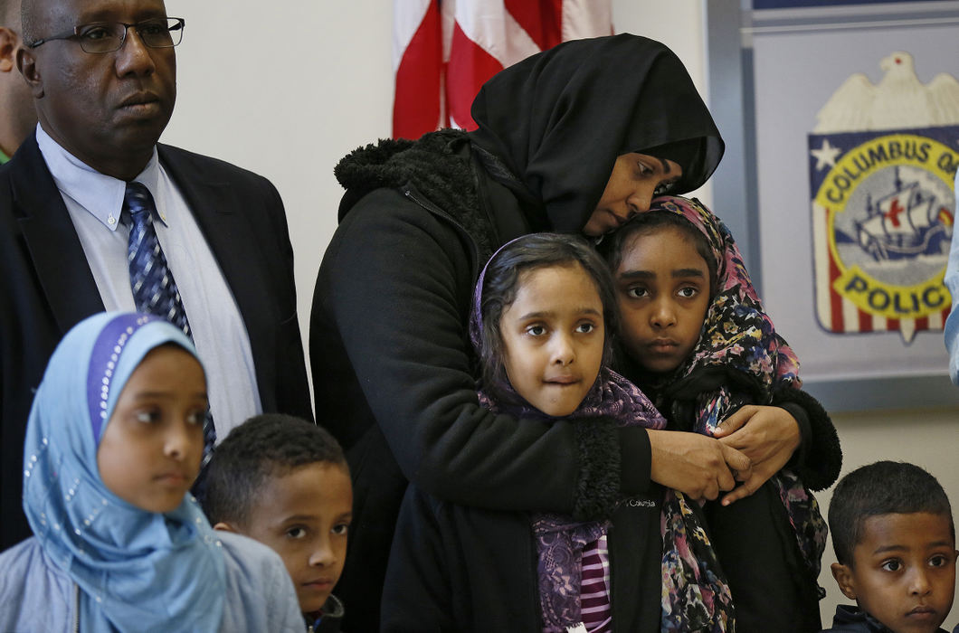 AGeneral News - 1st place - Widow Amal Mohamed holds her daughters Laila and Sureya, as Crimestoppers announces a $10,000 reward for information about the Oct. 23 killing of her husband Shueyb Abukar outside the Golden Corral during a press conference with Abukar's family at the Columbus Police Academy. (Adam Cairns / The Columbus Dispatch)