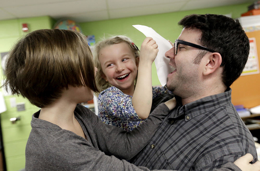 NEFeature - 1st place - James Weber shares a laugh with his two daughters, Zoe, 3, (center) and Sydney, 7, of Gahanna, while holding them up at Chapelfield Elementary School's annual family night. The open house event offered creative and physical activities for kids and adults, a book swap, dinner catered by Mi Tradicion Mexican Restaurant and an opportunity for parents to meet with faculty. (Shane Flanigan / ThisWeek Newspapers)