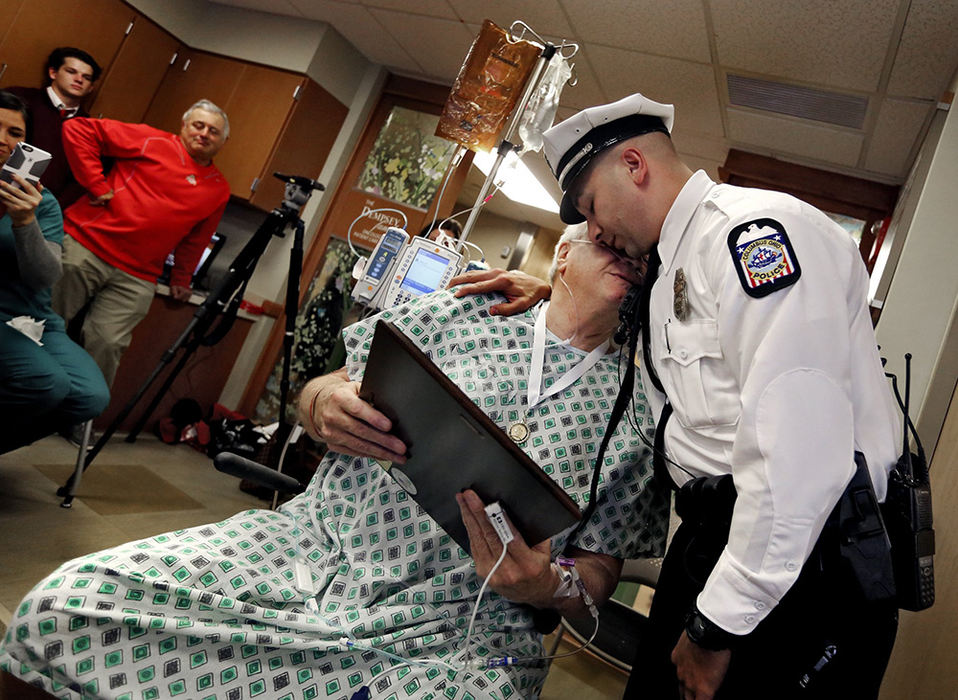 General News - 2nd place - Randy Rosser who has late stage lung cancer holds his sons Ryan Rosser's Medal Of Merit citation for his work on the arrest of a sexual assault suspect. Columbus Police conducted the award ceremony at Riverside Hospital so Randy could see his son receive his medal and citation.  (Eric Albrecht / The Columbus Dispatch)