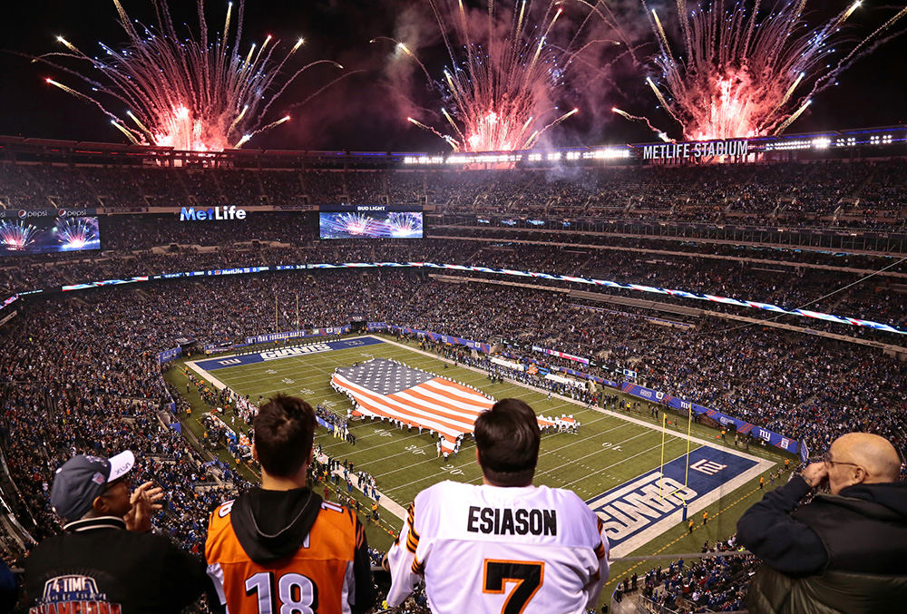 SSports Feature - 3rd place - Fireworks burst in the air above the stadium as a United States shaped flag is unfurled on the field during the National Anthem before the NFL Week 10 game between the New York Giants and the Cincinnati Bengals at MetLife Stadium in East Rutherford, N.J. (Sam Greene / Cincinnati Enquirer)