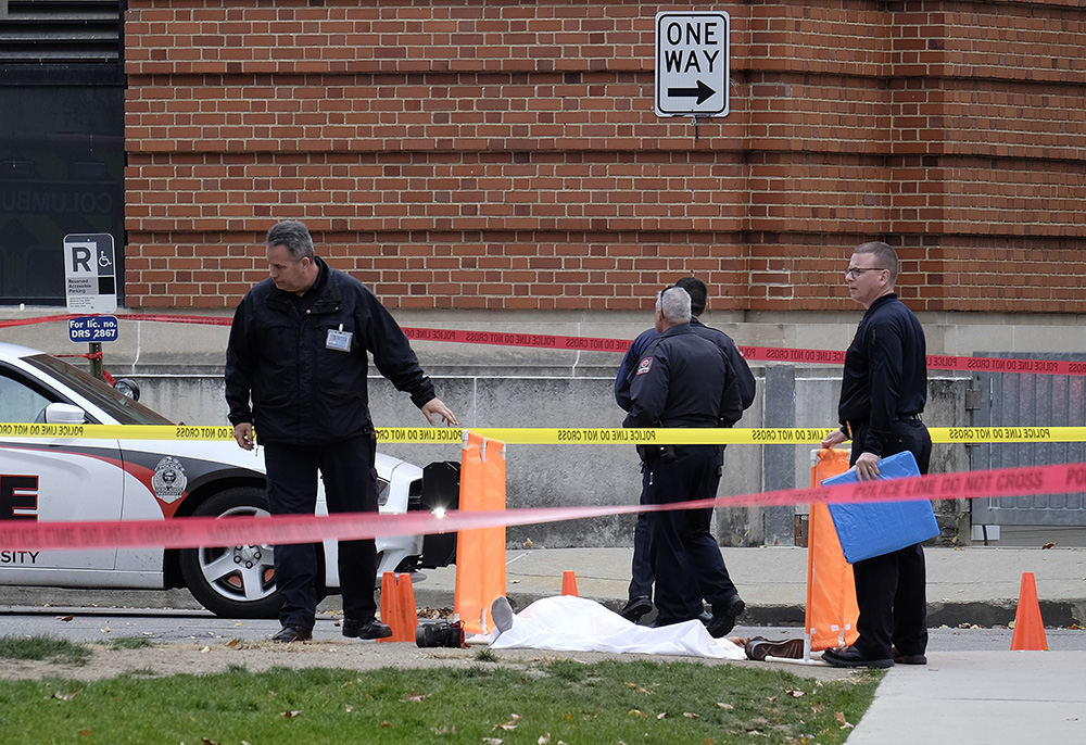 ASpot News - 1st place - Police cover the body of attack suspect  Abdul Razak Ali Artan along 19th Avenue, outside Watts Hall on Ohio State's campus. Artan allegedly drove his car into a crowd of people before he began slashing at them with a butcher knife, injuring 11. Artan was shot and killed by a campus police officer who was responding to a nearby fire alarm. (Adam Cairns / The Columbus Dispatch)