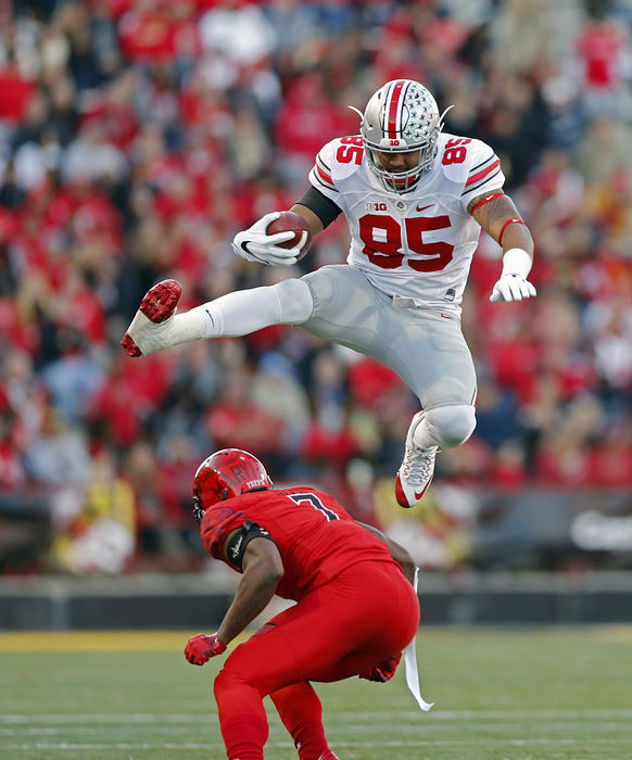 Sports - 1st place - November - First place SportsKyle Robertson/The Columbus DispatchOhio State tight end Marcus Baugh (85) leaps over Maryland defensive back JC Jackson (7) after making a catch during the first half at Maryland Stadium in College Park, Md.  (Kyle Robertson / The Columbus Dispatch)