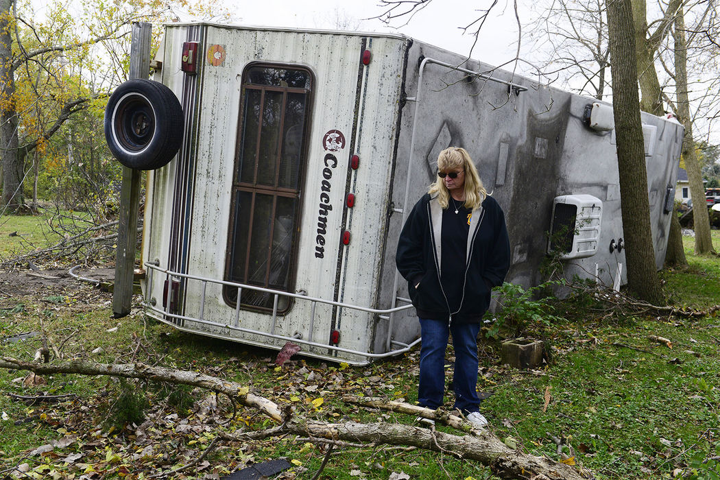 Story - 3rd place - Connie Weyer stands in front of her 32-foot Coachman camper. The force of the tornado picked the camper up, lifted it over a 10-foot deck and overturned it on its side. Three weeks before the tornado hit, a fire destroyed the family's barn which included five vintage cars and a vintage motorcycle. (Molly Corfman / The News-Messenger)