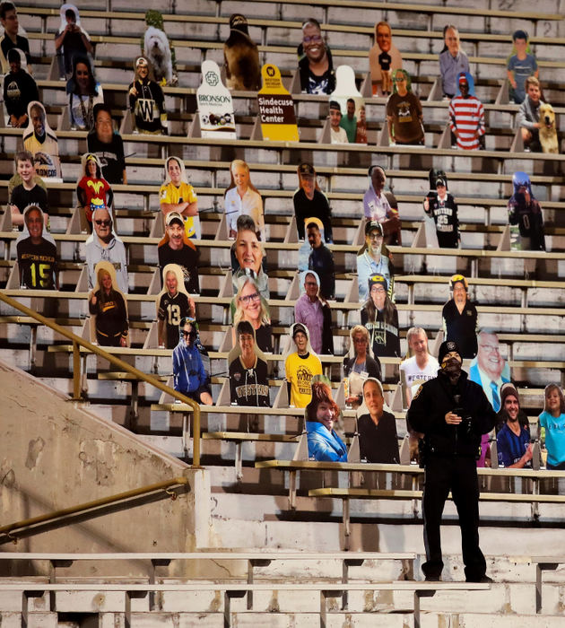 Sports Feature - 2nd place - A police officer stands in front of fan cardboard cutouts during a Mid-American Conference (MAC) college football game between Western Michigan and Toledo at Western Michigan University's Waldo Stadium in Kalamazoo, Michigan. Kurt Steiss / The Blade