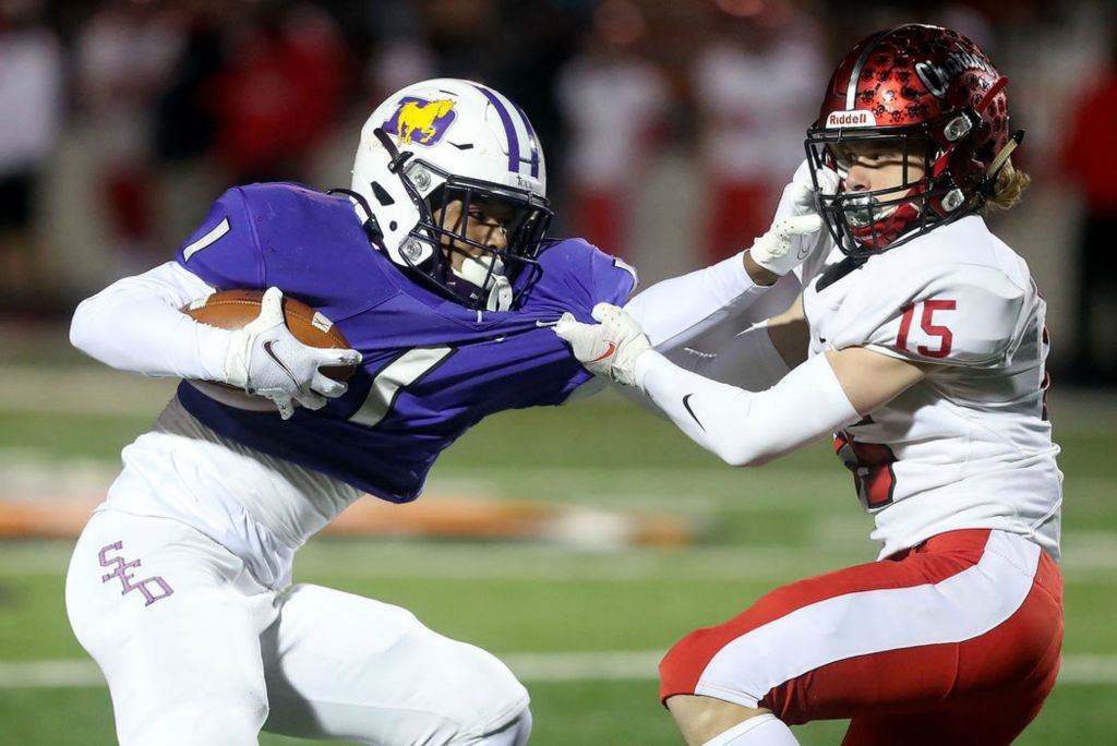 Sports - 1st place - DeSales' Jordan Johnson tries to fend off Chardon's Trey Liebhardt during the Division III State Championship game at Paul Brown Tiger Stadium in Massillon. Shane Flanigan / ThisWeek Community News