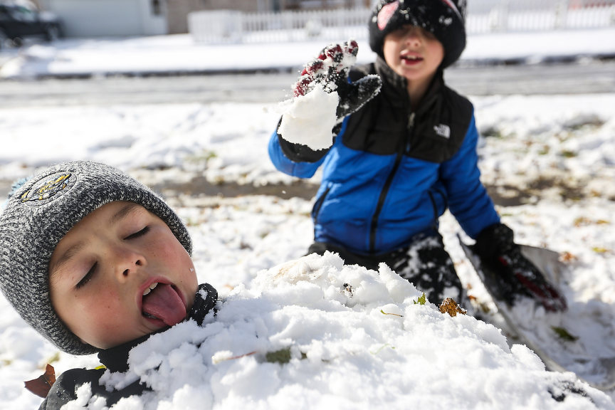 Feature - 1st place - Hunter Haberland (left) licks the snow as Blake Jankowski throws snow on him while burying him in Oregon, Ohio. (Rebecca Benson / The Blade)