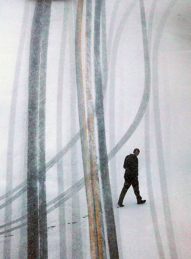 Feature - 2nd place - A pedestrian braves the cold and the snow as he walks out to his car parked on Selle Street in Akron. (Jeff Lange / Akron Beacon Journal)