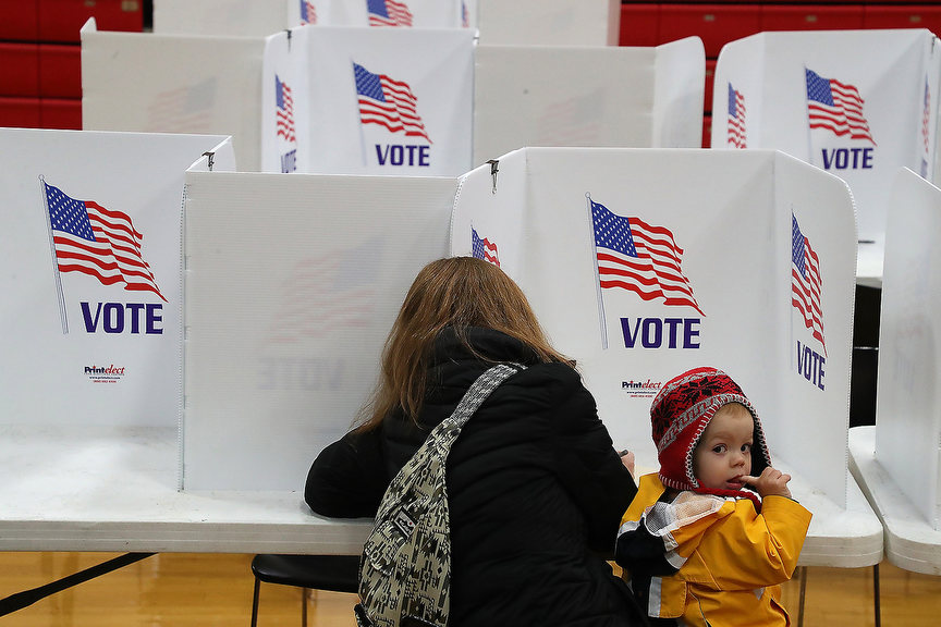 General News - 2nd place - Contour Sanford looks around the gym at Tecumseh High School as his mother, Erin, casts her vote.  (Bill Lackey / Springfield News-Sun)