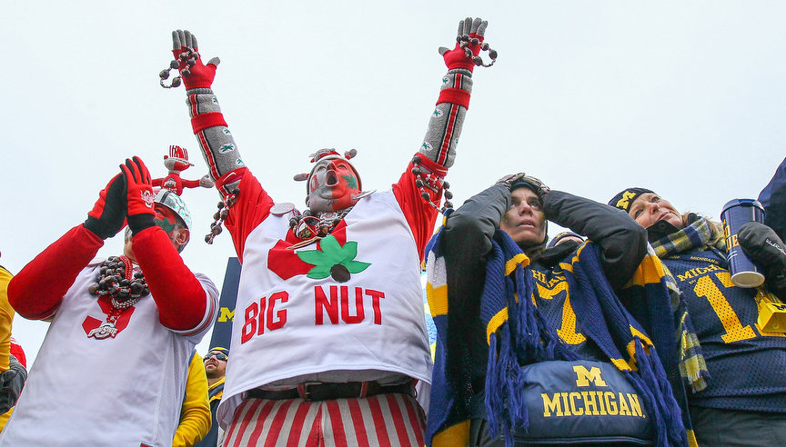 Sports Feature - 1st place - Ohio State super fan Jon "Big Nut" Peters of Fremont, celebrates as Michigan fans Rachael Kay and Erika Daniel both of Toronto, Canada, grimace during a Big Ten football game in Ann Arbor, Michigan. OSU defeated Michigan, 56-27. (Jeremy Wadsworth / The Blade)