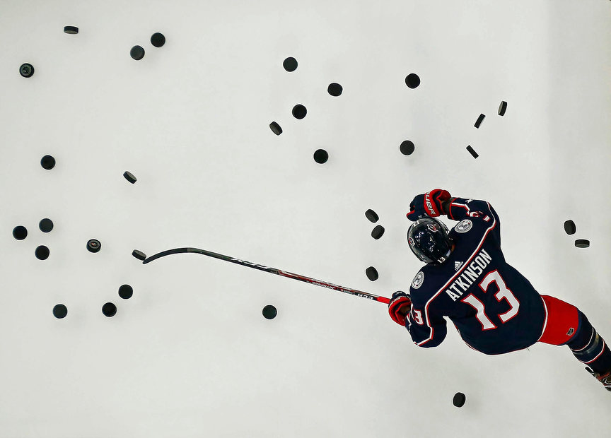 Sports Feature - 2nd place - Columbus Blue Jackets right wing Cam Atkinson knocks the pucks onto the ice for warm-ups prior to a NHL hockey game against the Ottawa Senators at Nationwide Arena in Columbus. (Adam Cairns / The Columbus Dispatch)