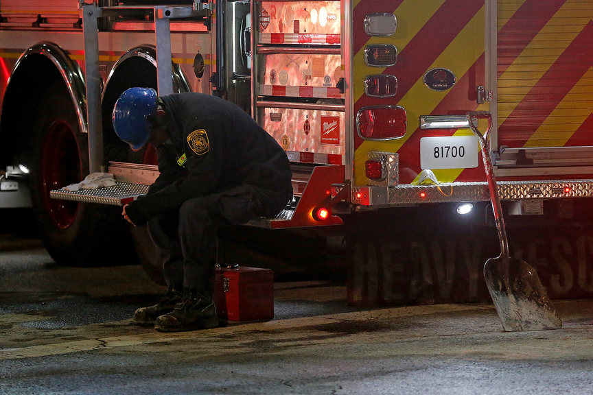 Spot News - 1st place - A Cincinnati firefighter rests between search party shifts inside the building at the scene of a partial building collapse at the construction site on W. 4th Street between Race and Elm Streets in downtown Cincinnati. Turner Construction announced that four injured workers were released from the hospital late Monday night, but search and rescue crews worked through the night in search of one missing worker, believed to be dead. (Sam Greene / The Cincinnati Enquirer)