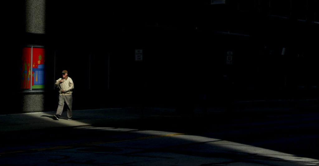 Feature - 1st place - A man zips up his coat while walking on Huron Street in Toledo.  (Jeremy Wadsworth / The Blade)