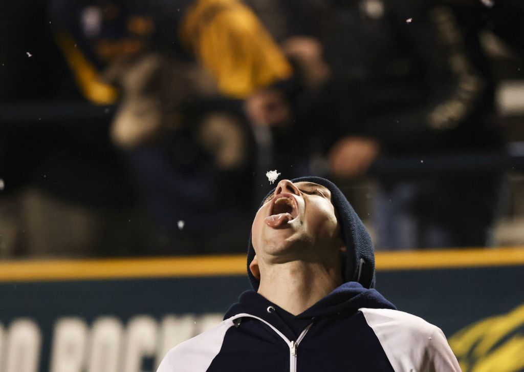 Sports Feature - 2nd place - A Toledo cheerleader catches a snowflake on his tongue during a MAC football game at the University of Toledo’s Glass Bow. BGSU defeated Toledo, 42-35.  (Rebecca Benson / The Blade)