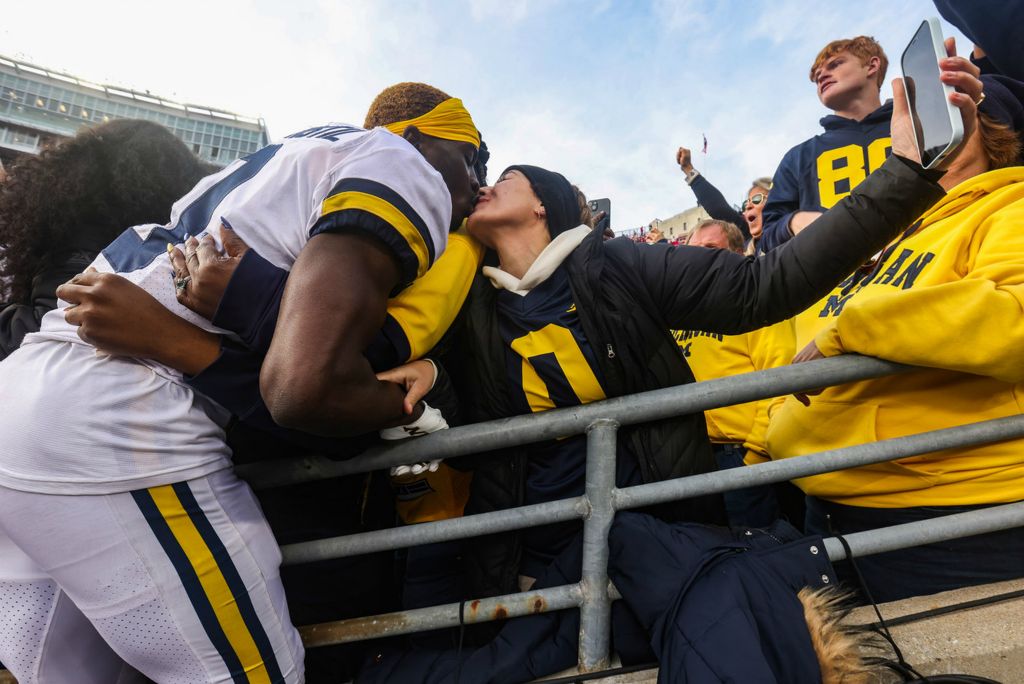 Sports Feature - HM - Michigan’s Mike Sainristil kisses his girlfriend Seliana Carvalho after defeating Ohio State, 45-23 at Ohio Stadium in Columbus.  (Rebecca Benson / The Blade)