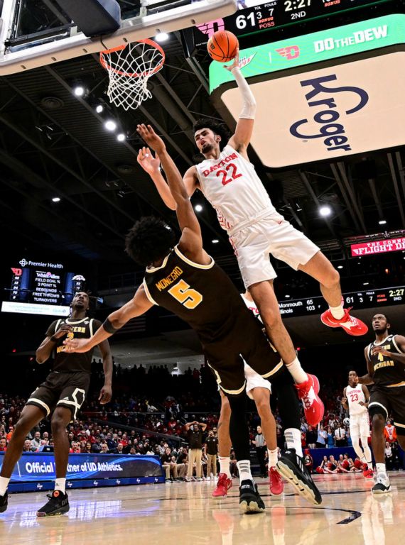 Sports - HM - Dayton's Mustapha Amzil charges to the hoop toppling over Jefferson Monegro from Western Michigan. Amzil was called for an offensive foul and the basket was not counted. Dayton defeated Western Michigan 67-47. (Erik Schelkun / Elsestar Images)