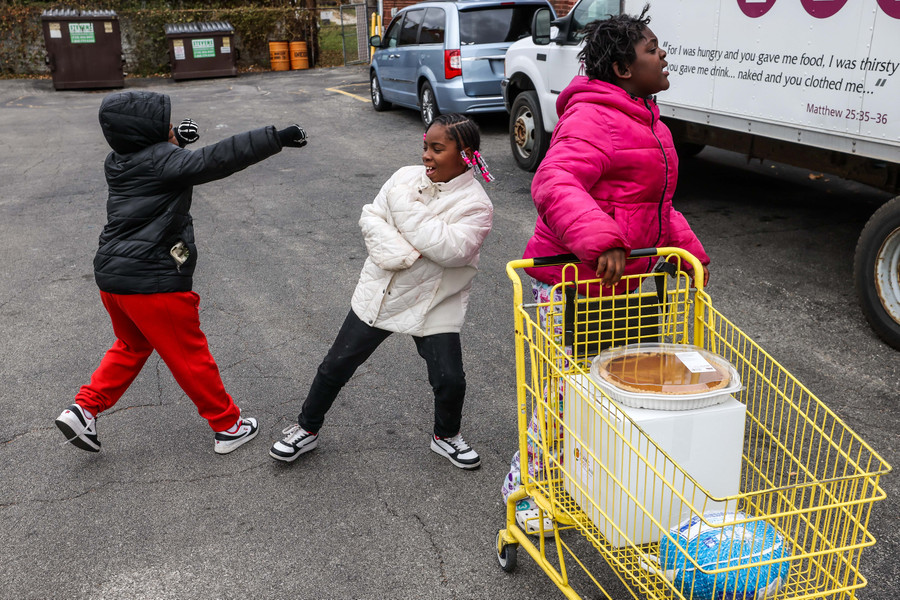 General News - HM - Toledo resident Teven, 8, (left) squares up against sister Ky’onna, 10, as the two play while waiting to receive a Thanksgiving meal box during a giveaway at Helping Hands of St. Louis in Toledo. (Isaac Ritchey / The Blade)