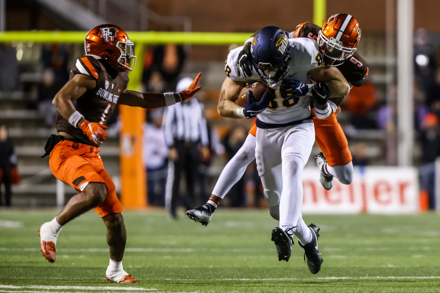 Sports - 3rd place - Toledo Rockets tight end Anthony Torres (center) carries Bowling Green safety Darius Lorfils for a few extra yards during the Battle of I-75 at Doyt Perry Stadium in Bowling Green. (Isaac Ritchey / The Blade)