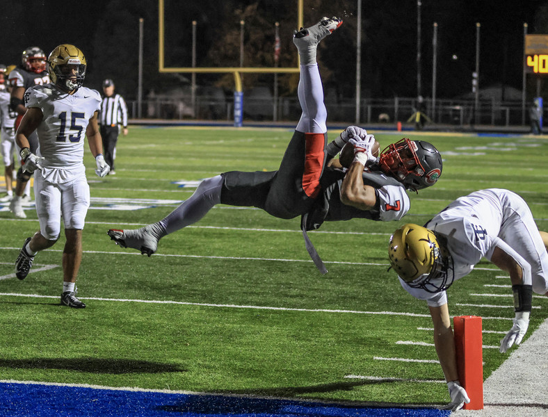 Sports - HM - Central Catholic running back Tyler Morgan goes airborne for extra yardage against  Tiffin Columbian defensive back A.J. Hickman during a Division III regional final playoff game at Robert J. Bishop Jr. Stadium in Clyde.   (Jeremy Wadsworth / The Blade)