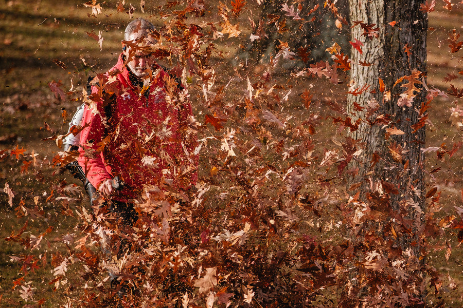 Feature - 1st place - Jan Herron blows leaves at Tuscora Park in New Philadelphia. (Andrew Dolph / The Times Reporter)