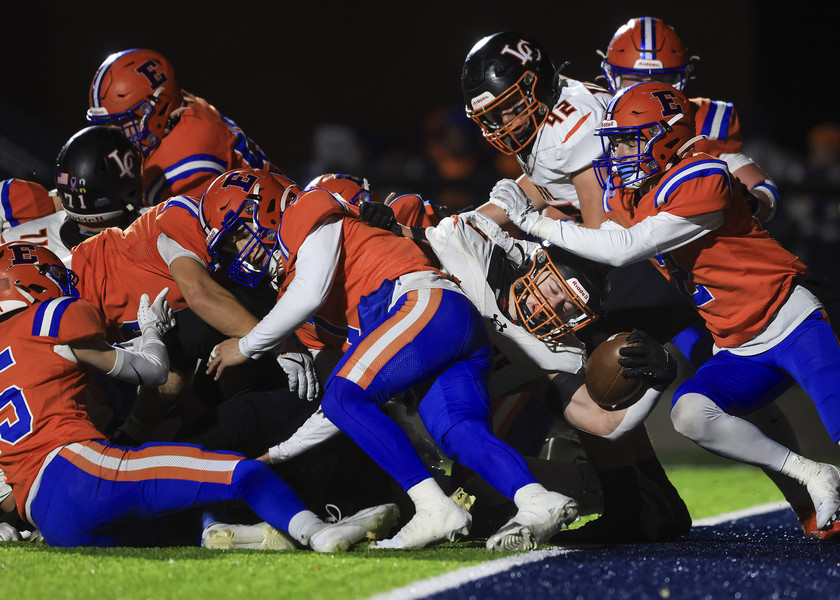 Sports - HM - Liberty Center’s Waylon Rentz reaches the ball into the end zone for a touchdown against a host of Edison defenders during the high school football Division V regional final at Lake High School in Millbury. (Rebecca Benson / The Blade)