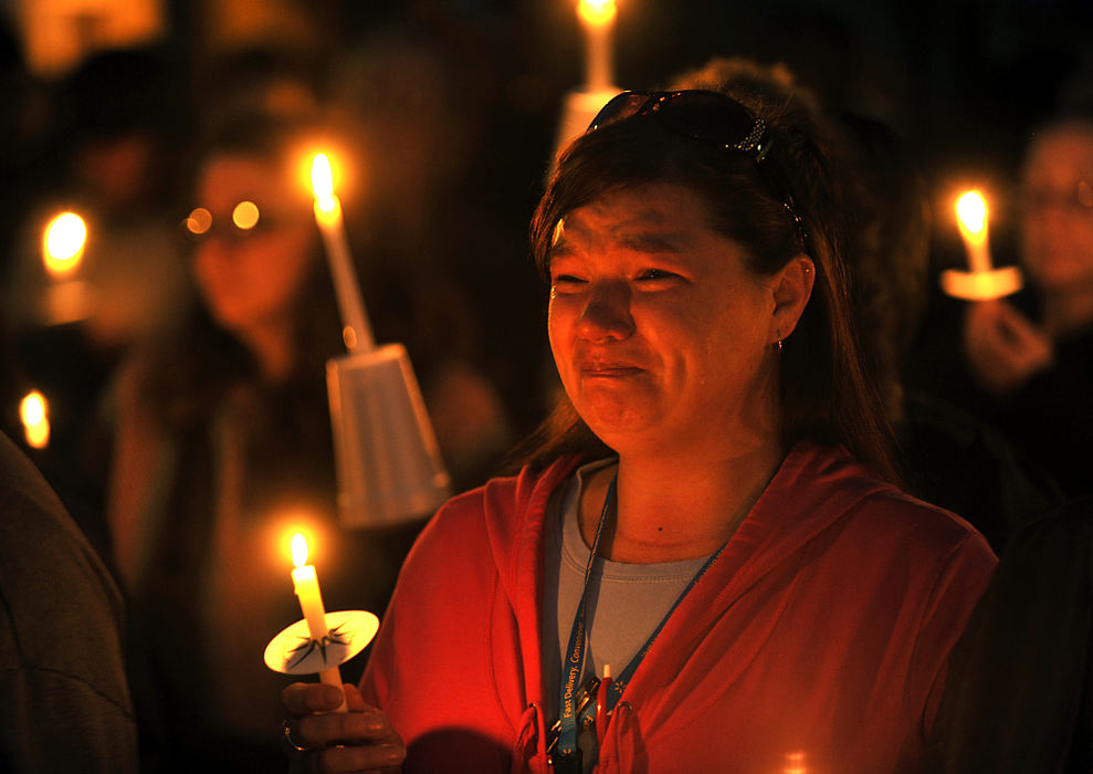 General News - 1st place - Lisa Jo Rice fights back tears as she participates in the Cease the Fire Candlelight Vigil with several hundred other Springfield residents at the intersection of Perrin Avenue and Center Street where Dovon Williams and Aubrie Smith were shot to death a week earlier. (Bill Lackey / Springfield News-Sun)