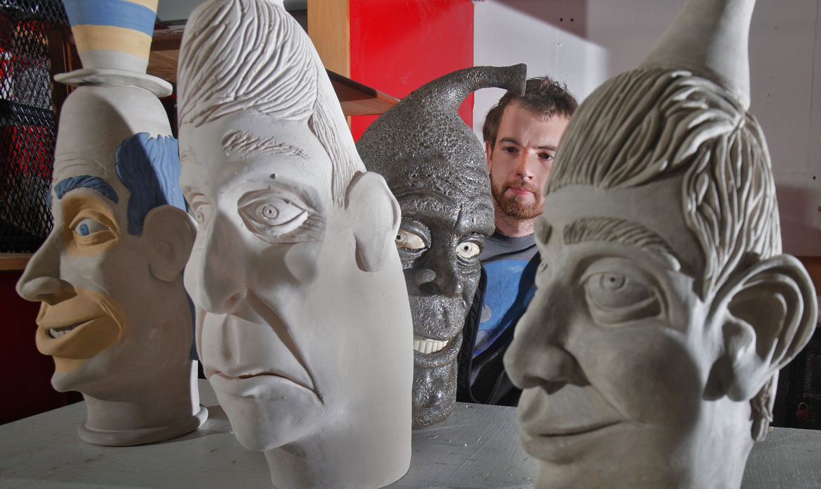 Portrait - HMRoyce Hilderbrand with some of his Face Jugs at CCAD. Royce, a senior fine art major said he has made about 50 of the Face Jugs this year after his professor taught him about old moonshine vessels. Royce said that although practical, his artwork is intended as gallery work and not for moonshine.  (Tom Dodge / The Columbus Dispatch)