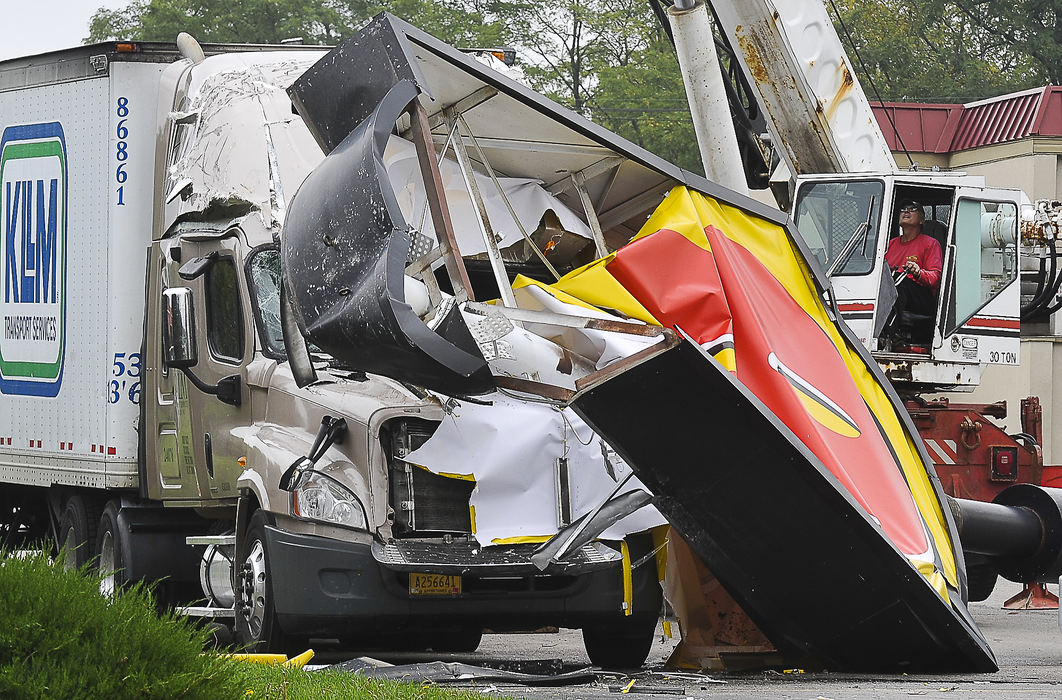 Spot News - 2nd placeA crane operator from KRN Crane Service prepares to  lift the giant Motel 8 sign off the cab of a semi-truck parked in its parking lot along Leffel Lane in Springfield. According to witnesses, the sign was blown over by the wind. There were no injuries reported but the truck was severely damaged. (Bill Lackey / Springfield News-Sun)