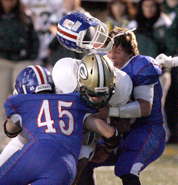 Sports - HMLake's Doug Michel, gets separated from his helmet while making a tackle on GlenOak's Jason Simon during the first quarter of their game. Also in on the tackle for Lake was Matt Blasiole, 45. (Scott Heckel / The Repository)