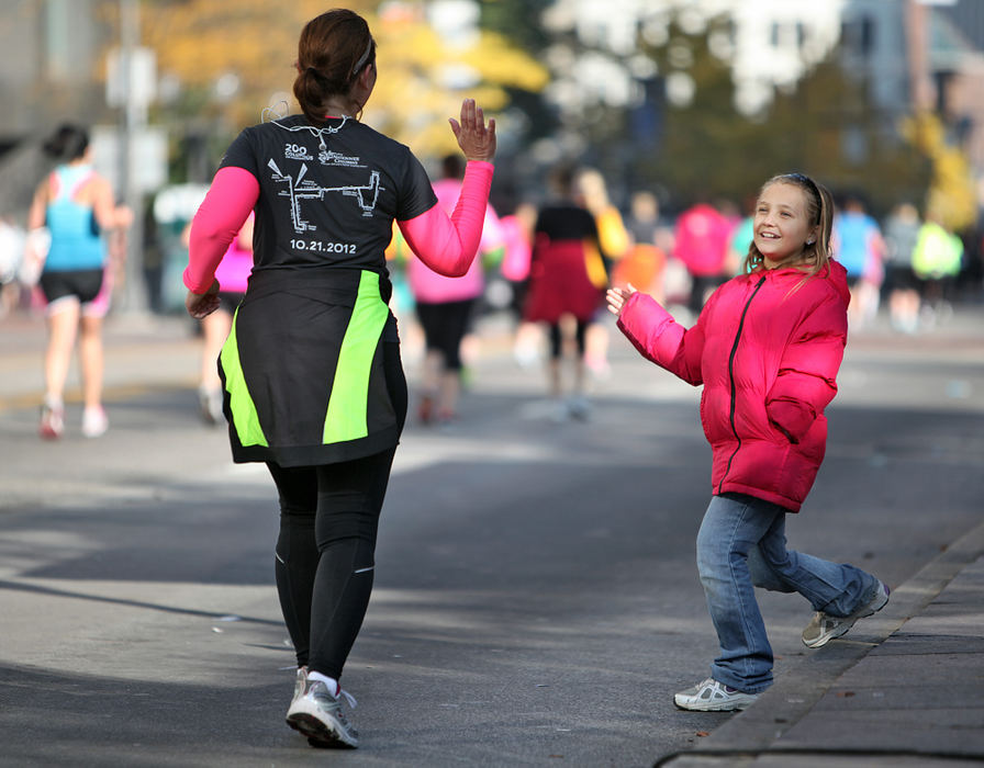 Story - 2nd placeNatalie Hosey, 9, stands along High Street and offers a high five to a passing runner in the Nationwide Children's Hospital Columbus Marathon.   (Chris Russell / The Columbus Dispatch)