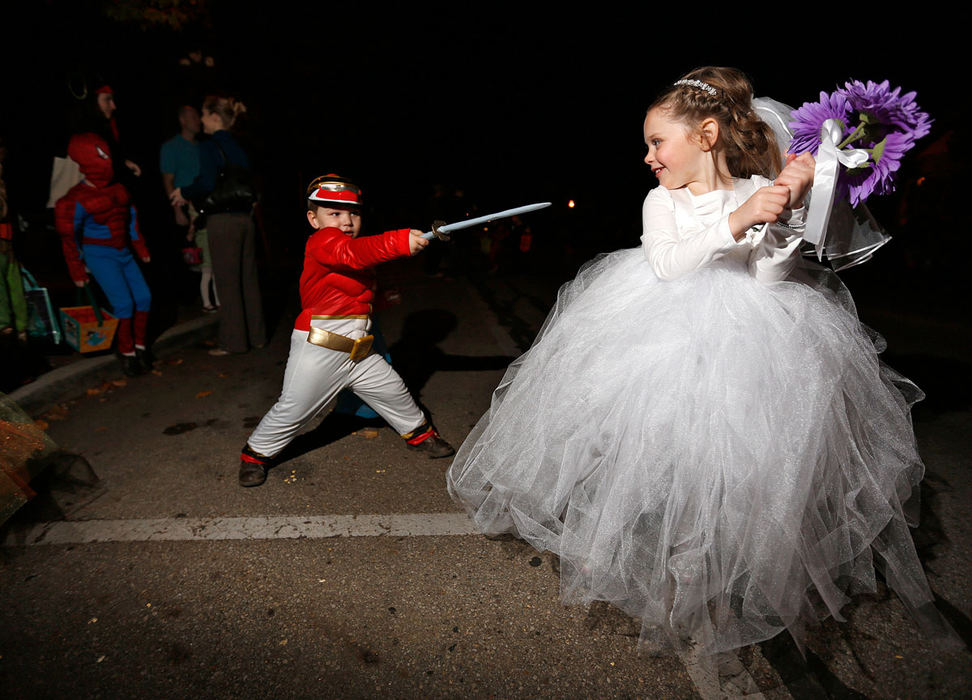 Feature - 3rd placeGavin Hill, of Pickerington (as a Red Power Ranger) plays with his friend Brooklyn Sturtz, of Hebron (as a runaway bride) on Columbus St. in Pickerington during the annual Haunted Village event. (Jonathan Quilter / The Columbus Dispatch)