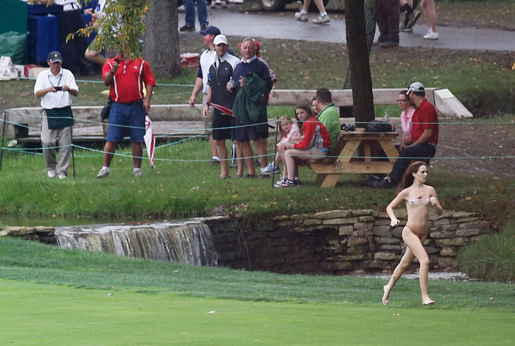 Spot News - 1st placeA woman streaks across the 18th fairway during the final round of the Presidents Cup at Muirfield Village Golf Club in Dublin. The Americans held on to the Presidents Cup in a rain and mud soaked final round win over the International Team with a score of 18.5 - 15.5.  (Eamon Queeney / The Columbus Dispatch)