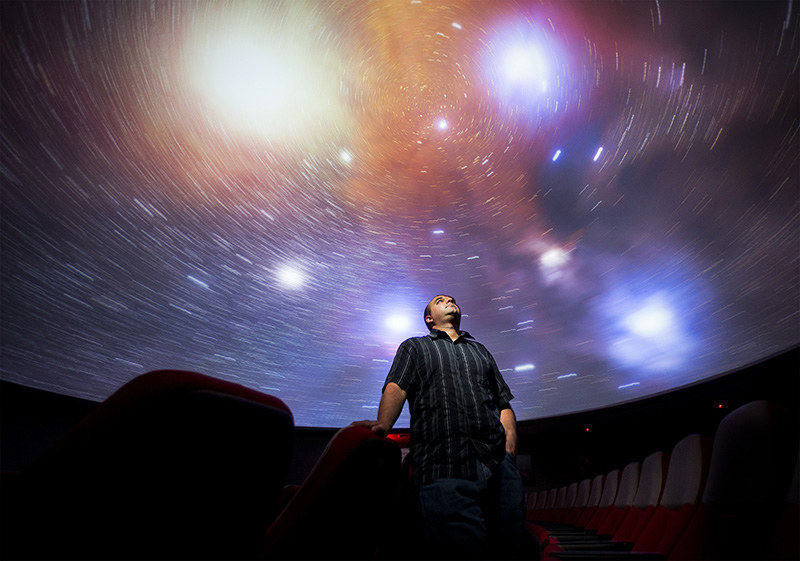 Portrait - 1st place - Wayne Schlingman, Ohio State University's new planetarium director, poses for a photograph inside the planetarium in Smith Laboratory with the Rho Ophiuchi nebula spinning above him.  (Eamon Queeney / The Columbus Dispatch)