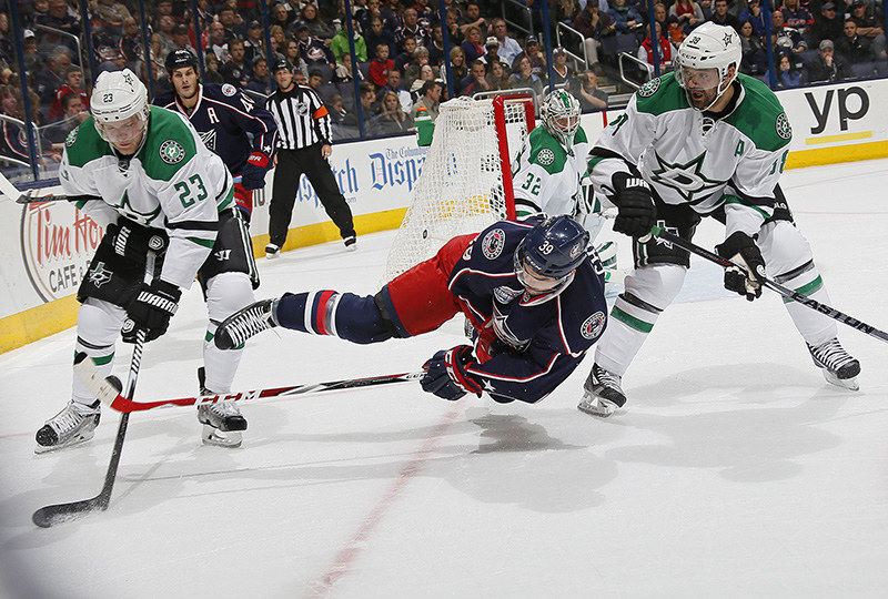 Sports - 3rd place - Columbus Blue Jackets center Michael Chaput (center) tries to knock the puck away from Dallas Stars defenseman Kevin Connauton (23) as he falls to the ice in the first period at Nationwide Arena in Columbus. (Eamon Queeney / The Columbus Dispatch)