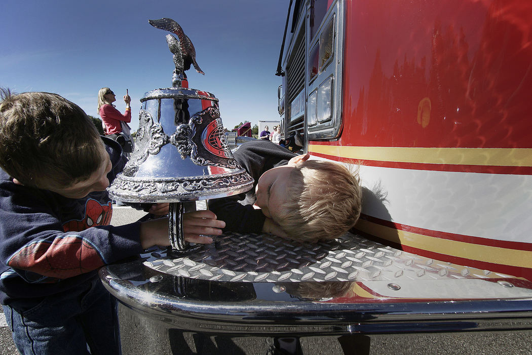 General News - 1st place - Brothers Saulton (left), 6, and Nolan, 4, of Ontario try to ring the bell on a fire truck during the Hands on Trucks event at Marshall Park in Ontario.   (Mitchell Pe Masilun / The (Mansfield) News Journal)