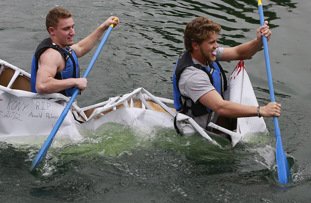 Feature - 2nd place - Josh Gazica (left) and Logan Eby, students at Cedarville College, paddle furiously for the shore as their cardboard boat breaks apart and sinks in Cedar Lake during the annual Cedarville College Cardboard Boat Races.  (Bill Lackey / Springfield News-Sun)