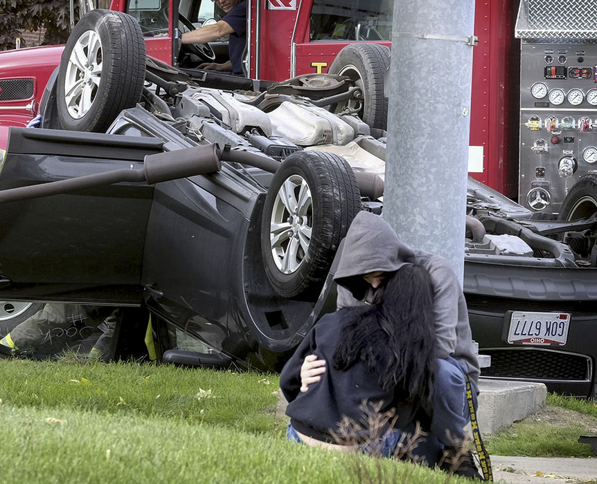 Spot News - 1st place - Meagan Insco, 17, is consoled following a rollover accident at the corner of Manhattan and Stickney. Toledo police said the young woman was traveling westbound on Manhattan and turned in front of another vehicle. They cited her for failure to yield during a left turn.  (Andy Morrison / The (Toledo) Blade)