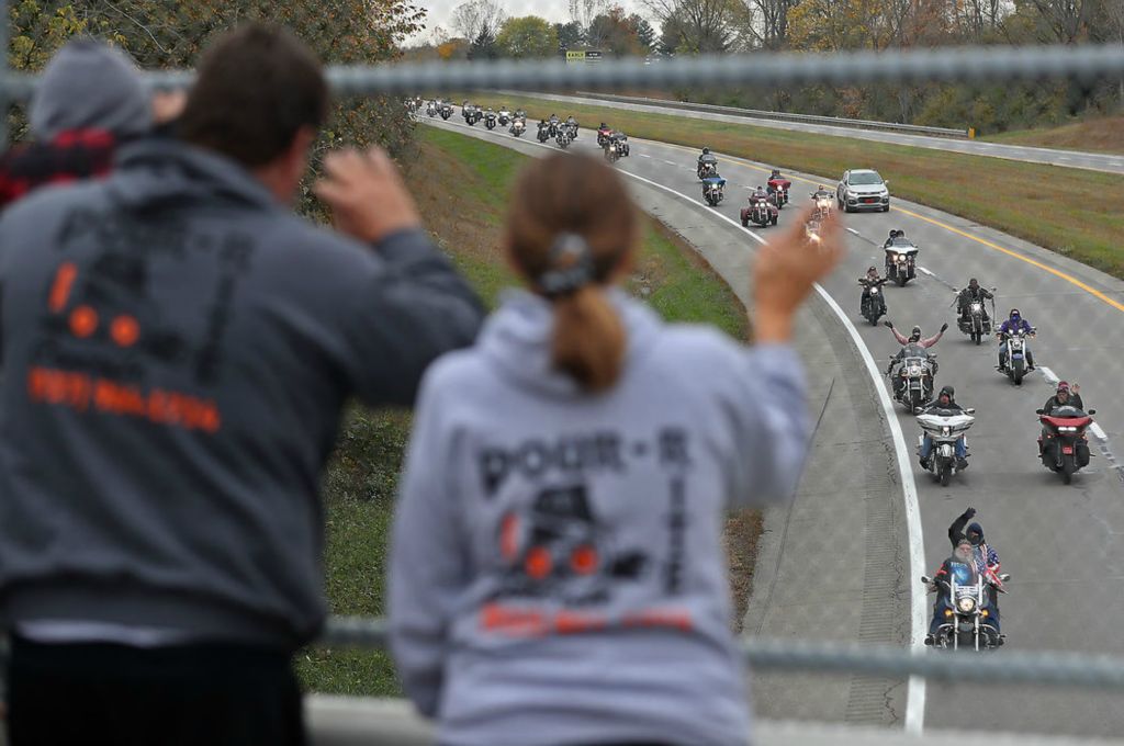 General News - 1st place - A family waves from an overpass at the motorcyclists below participating in the 42nd Annual Highway Hikers Toy Run. Over 1,500 motorcyclists rode across Clark County to deliver toys and donate money at the Clark County Fairgrounds for the Salvation Army Christmas Toy Drive. Bill Lackey / Springfield News-Sun