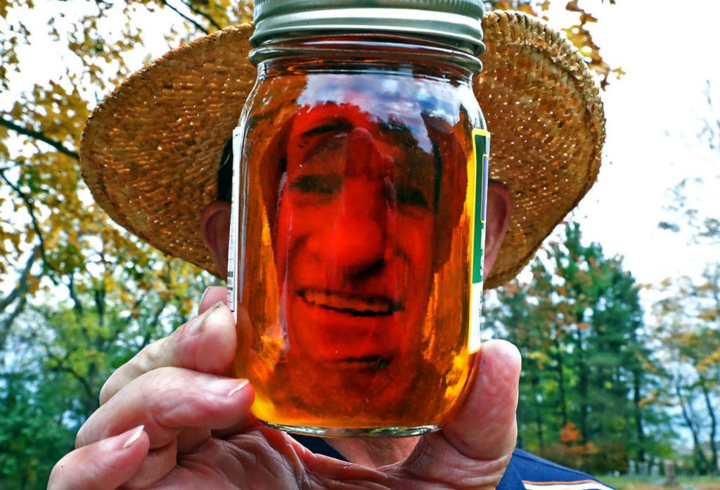 Portrait - HM - Ben Hamilton looks thru a jar of pure maple syrup that he made from Sugar Maple trees in Clark County.  Bill Lackey / Springfield News-Sun