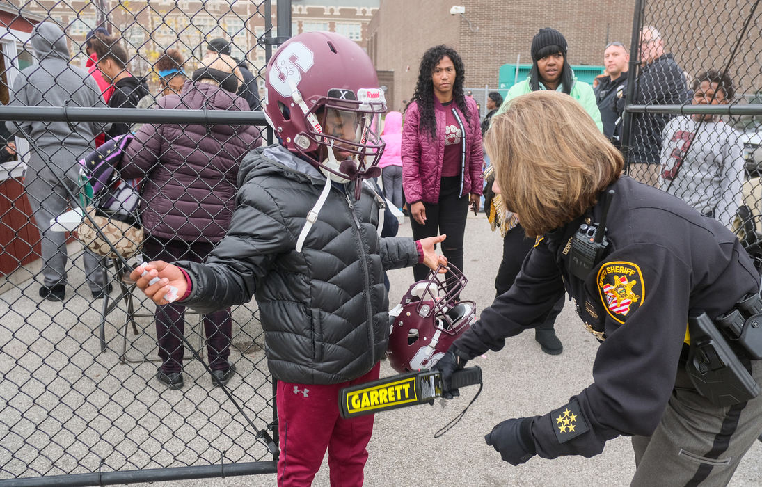 General News - 3rd placeKeith Reid, 12, is wanded by Lucas County Sheriff's Deputy Karen Villareal as he enters the stadium for the football game between Scott High School and Woodward High School at Scott High School in Toledo. New security measures are in place for City League football games in light of recent shootings near the games. Start times have been moved up to 5:30.  ID's are being checked and only students from participating schools are being permitted to enter. (Jeremy Wadsworth / The Blade)