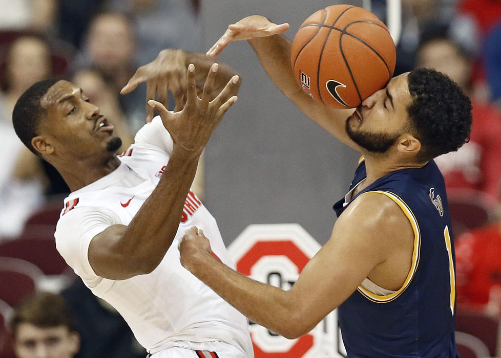 Sports - 2nd placeOhio State guard Luther Muhammad (left) grabs a rebound off the face of Cedarville guard Demond Parker during the first half of their game at Value City Arena in Columbus. (Kyle Robertson / The Columbus Dispatch)