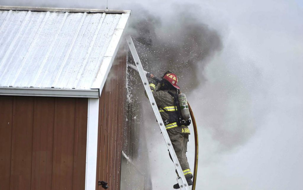 Spot News - 1st place - Rockford, Celina, Mendon, Chattanooga, Ohio City, Montezuma and Coldwater fire departments respond to a structure fire at Levi Auction Service on Sites Road. (Daniel Melograna / The Daily Standard) 