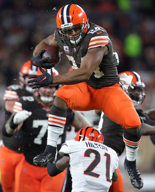 Sports - 2nd place - Cleveland Browns running back Nick Chubb (24) hurdles Cincinnati Bengals cornerback Mike Hilton (21) as he rushes for a first down during the first half of a game at FirstEnergy Stadium in Cleveland. (Jeff Lange / Akron Beacon Journal)