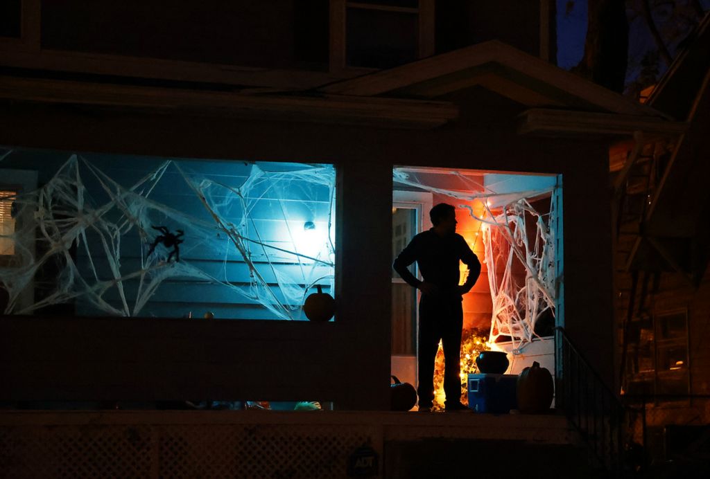 Feature - 3rd place - A resident waits on his decorated front porch for trick or treaters. The sidewalks in Springfield were filled with ghouls and goblins with the occasional super hero and princess thrown in for good measure during this year's Trick or Treat in Clark County.  (Bill Lackey / Springfield News-Sun)