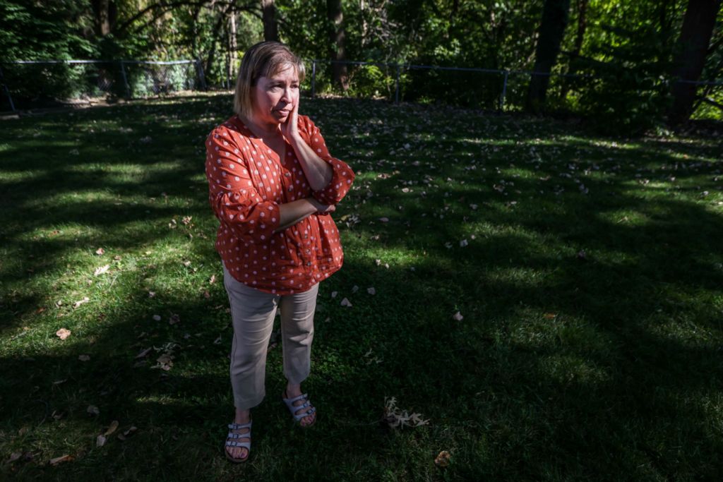 Portrait - 3rd place - Toledo resident Pamela Sobecki stands in her backyard where she watched investigators recover the body of neighbor Nancy Lewton, 71 in East Toledo. Court documents allege that Travis Lewton, 31, fatally strangled his mother, set her body on fire and stuffed her into a sewer pipe behind their home. (Isaac Ritchey / Sentinel-Tribune )