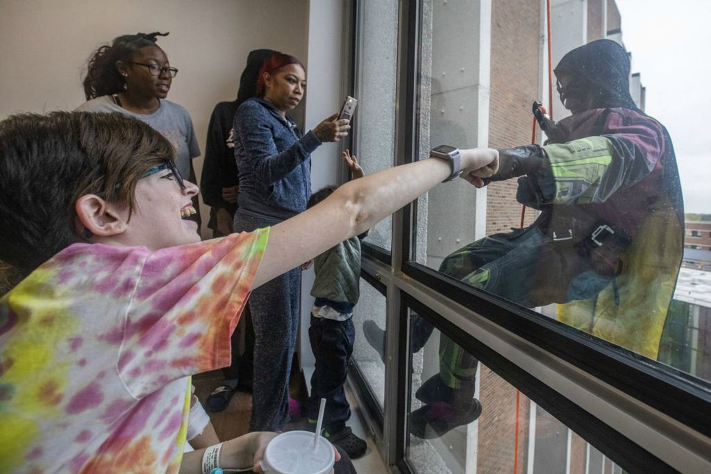 General News - HM - Nova Viers, 16, gives Robin a fist bump through the glass as Toledo Police Department’s SWAT team rappels down the walls of Mercy Health - St. Vincent Medical Center in Toledo. (Rebecca Benson / The Blade)