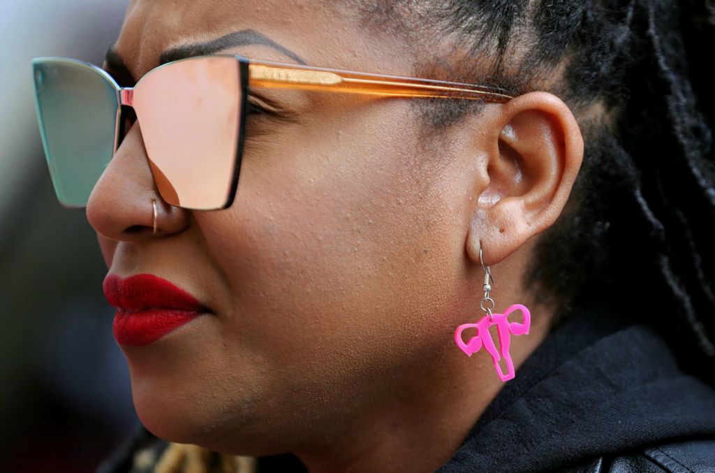 Portrait - 3rd place - An earring depicting female reproductive system hangs from the ear of Courtney Johnson-Benson of North Canton as she listens to speakers during the Bans Off Akron rally for reproductive rights outside Akron City Hall. (Jeff Lange / Akron Beacon Journal)