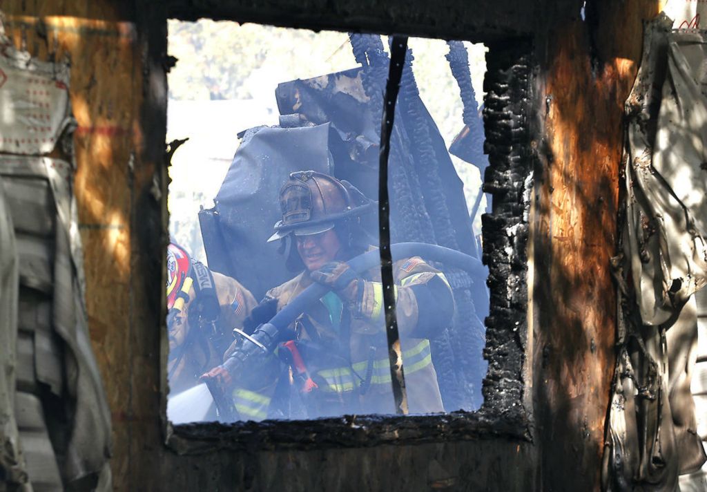 Spot News - 2nd place - Firefighters from several area departments battled a fire in a modified trailer on Oak Street in South Charleston. According to Madison Township Fire Chief Chris Clark, the home was fully involved when they arrived on the scene. He said the Red Cross was called for the two people who lived there and lost everything in the fire.  (Bill Lackey / Springfield News-Sun)